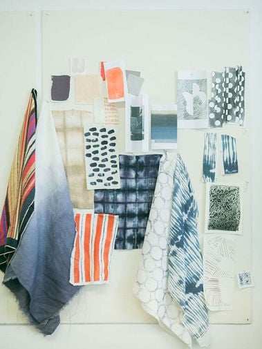 Textile mood board with layered colorful striped, geometric, mottled, and patterned fabric swatches on a pale panel.