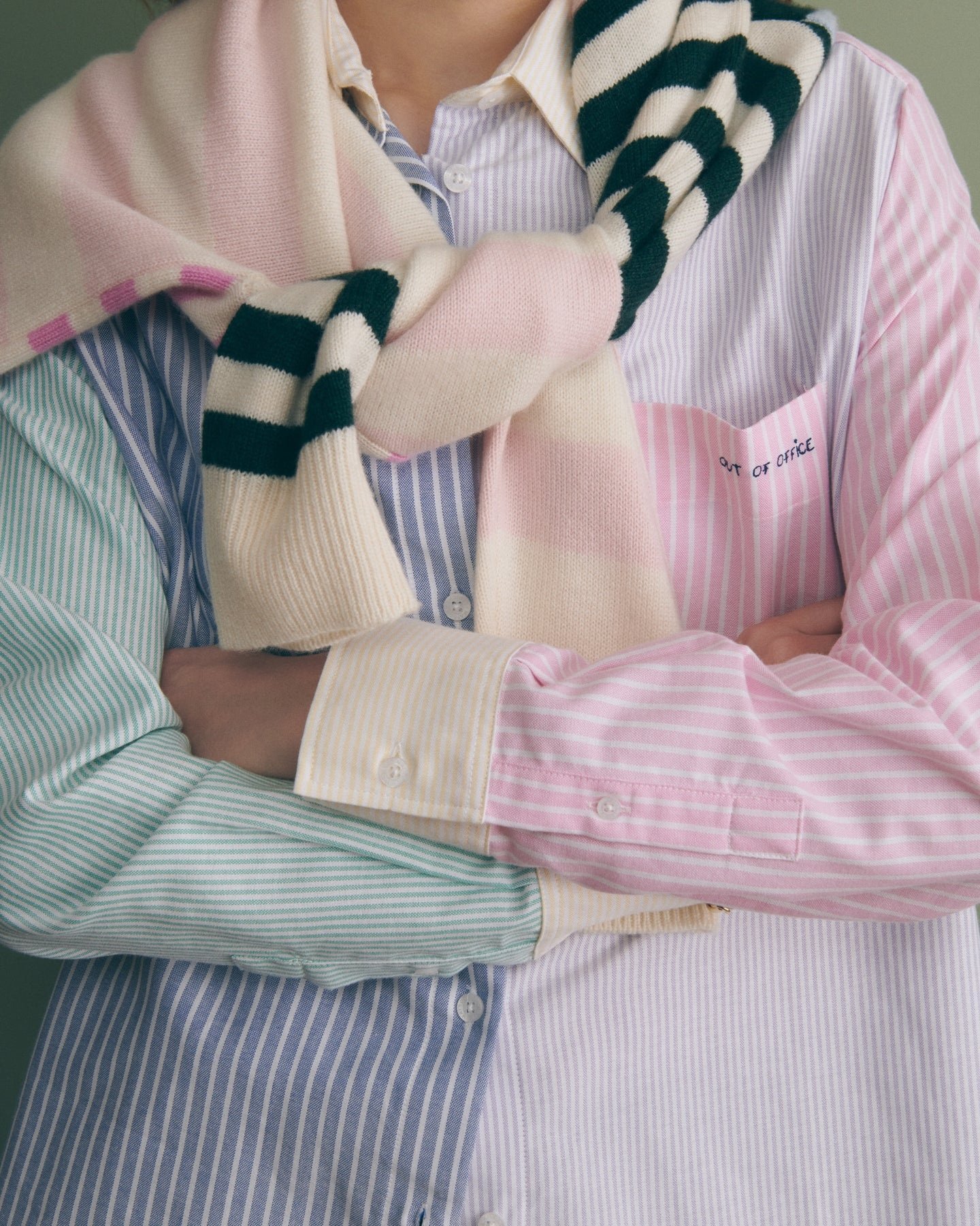 Cropped torsos in pastel-striped shirts with a cream, pink, and dark green striped scarf.